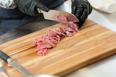 The cook cuts the meatloaf.