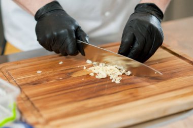 The cook cuts vegetables with a knife to prepare the dish. Cutting vegetables.