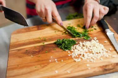 The cook cuts vegetables with a knife to prepare the dish. Cutting vegetables.