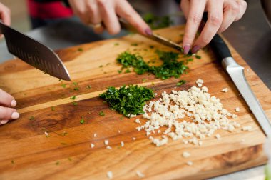 The cook cuts vegetables with a knife to prepare the dish. Cutting vegetables.