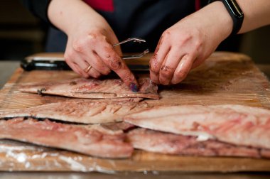 The cook separates the fillet from the fish and clears it from the bones. Mackerel fillets.