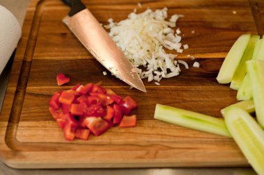 The cook cuts vegetables with a knife to prepare the dish. Cutting vegetables.