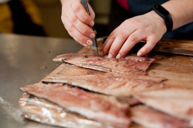 The cook separates the fillet from the fish and clears it from the bones. Mackerel fillets.