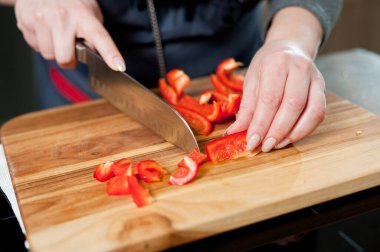 The cook cuts vegetables with a knife to prepare the dish. Cutting vegetables.