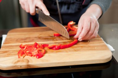 The cook cuts vegetables with a knife to prepare the dish. Cutting vegetables.