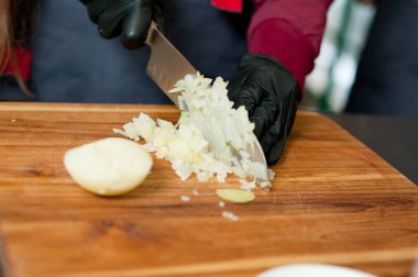 The cook cuts vegetables with a knife to prepare the dish. Cutting vegetables.