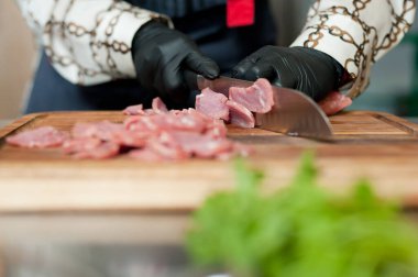 The cook cuts the meatloaf.