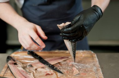 The cook separates the fillet from the fish and clears it from the bones. Mackerel fillets.