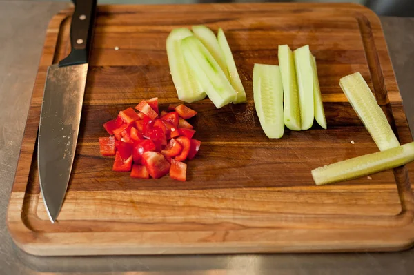 The cook cuts vegetables with a knife to prepare the dish. Cutting vegetables.