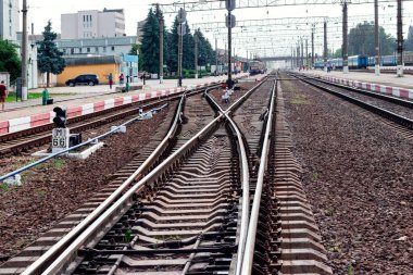 Rayları, binaları ve trenleri olan tren istasyonu.