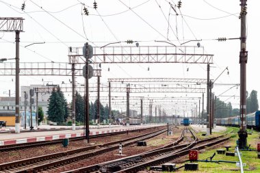 Rayları, binaları ve trenleri olan tren istasyonu.