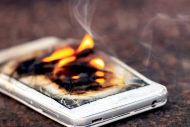 Mobile phone, smartphone, on fire. Burning smartphone