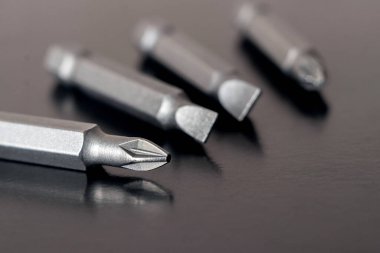 Koyu kahverengi arka plandaki vidaları sıkmak için parçalar ve başlıklar