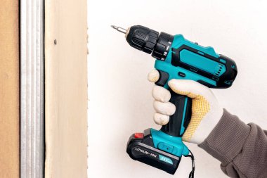 Usta metal profile alçıpan takmak için elektrikli tornavida kullanıyor.