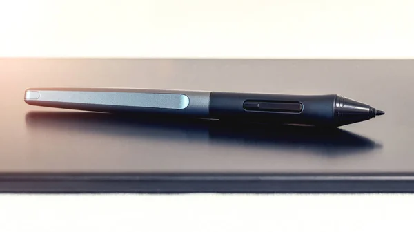 Graphic tablet and pen, stylus, with stand on a light background