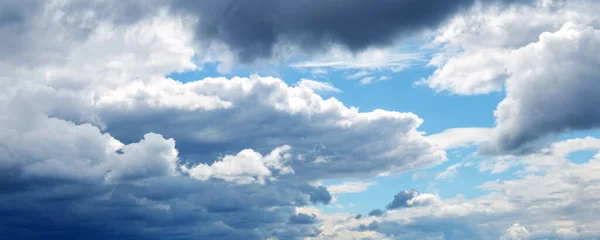 Heavy dark big clouds in the blue sky. Dramatic sky with blue and gray clouds