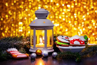 Christmas and New Year's card with lantern, Christmas cookies, Christmas tree branches and Christmas decorations on a bright bokeh background
