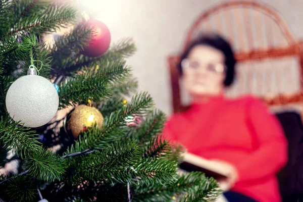 Elderly Woman Reads Book Bible Wicker Chair Front Christmas Tree — Fotografia de Stock