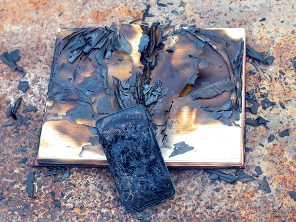 火灾后金属表面上的烧焦的电话和书籍 — 图库照片