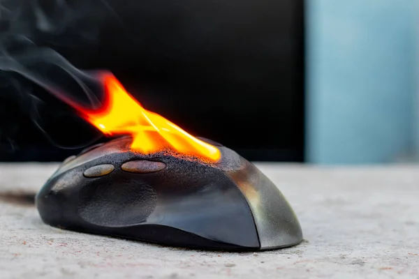 Computer mouse in flames. Careless handling of equipment, fire