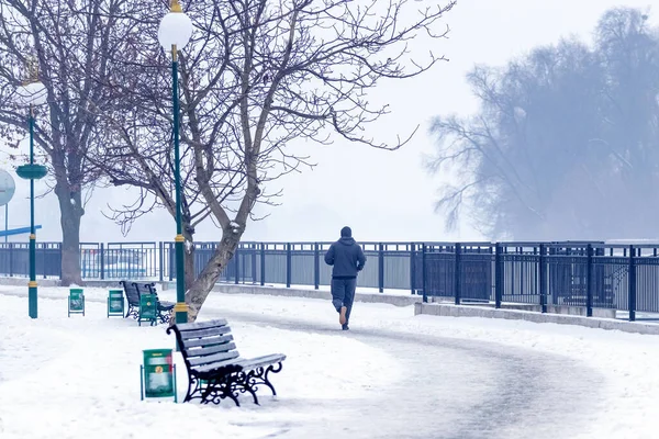 Man jogging in winter park, healthy lifestyle