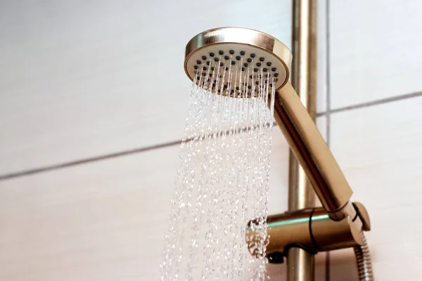 The flow of water from the watering can in the shower, close-up. Taking a shower