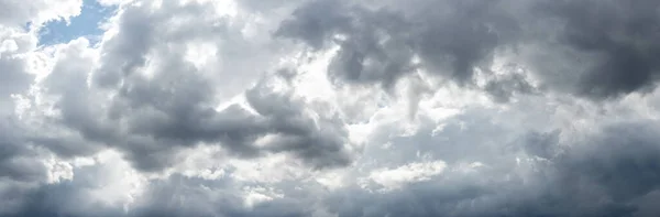 灰色の嵐の雲が空を厚く覆い 太陽の光が雲を貫通する — ストック写真