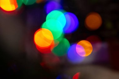 Soyut bir arkaplan, koyu bir arka planda ışıldayan parlak büyük bir bokeh. Tatil kavramı