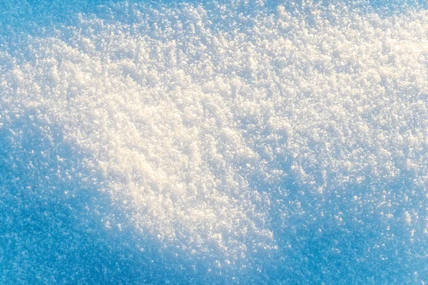 Texture of snow in sunny weather. Snow cover with snow crystals