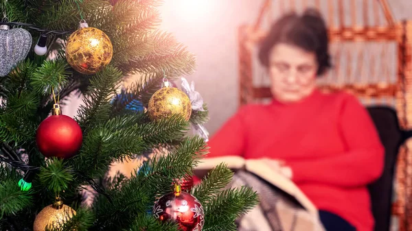 Elderly Woman Reads Book Bible Wicker Chair Front Christmas Tree — Fotografia de Stock