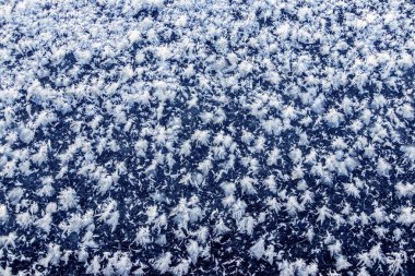 Big fluffy snowflakes on the surface of the ice. Winter and Christmas background