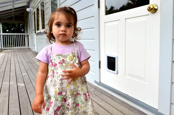 Niña de pie en un viejo balcón de casa . — Foto de Stock