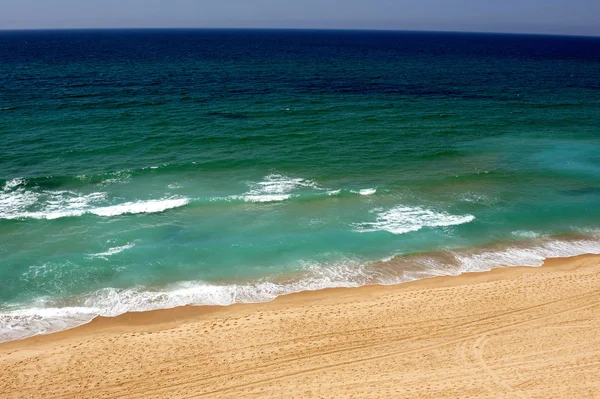 Waves wash over golden sand — Stock Photo, Image