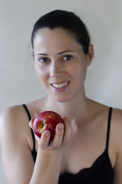 Młoda kobieta trzyma jabłko na białym tle — Zdjęcie stockowe