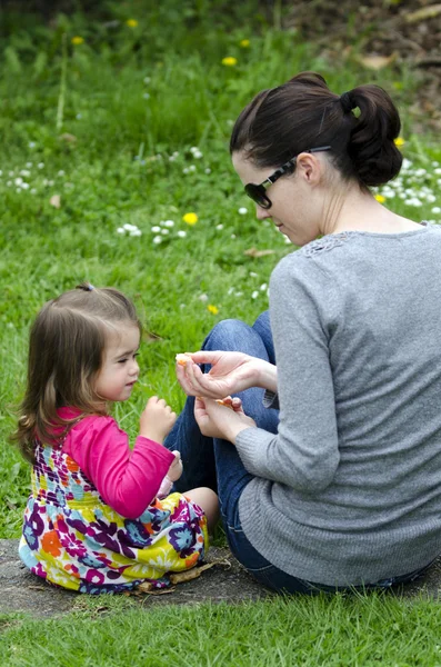 Petite fille mange des fruits mandarins avec sa mère — Photo