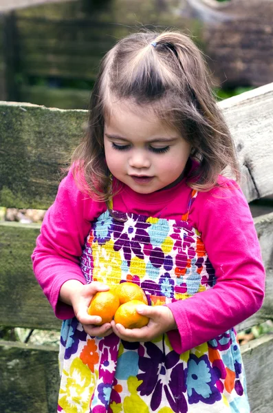 Menina detém frutas mandarim — Fotografia de Stock