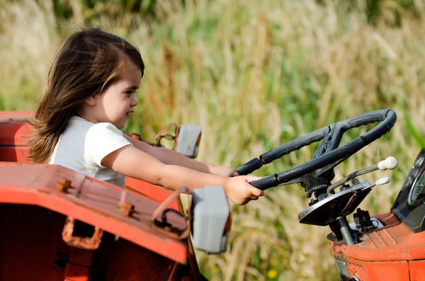 Kleines Kind sitzt auf altem Traktor — Stockfoto