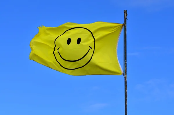 Drapeau jaune avec visage souriant — Photo