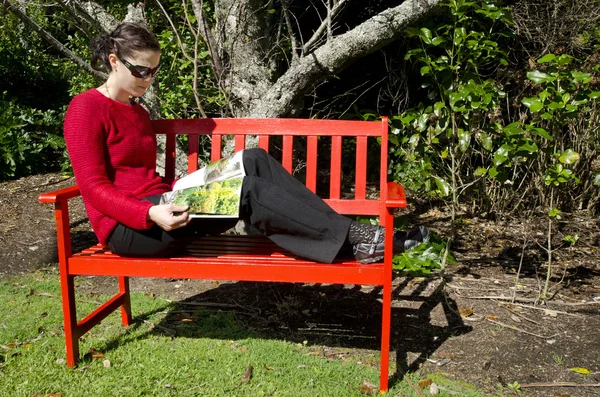 Donna legge in giardino — Foto Stock