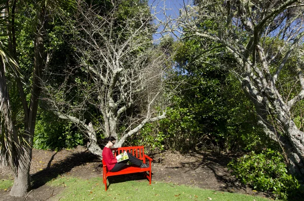 Mulher lê no jardim — Fotografia de Stock