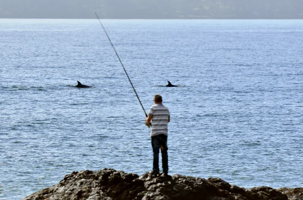 Homme pêchant dans un rocher — Photo