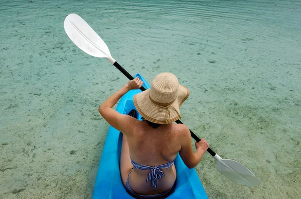 Joven mujer caucásica kayak sobre agua turquesa — Foto de Stock