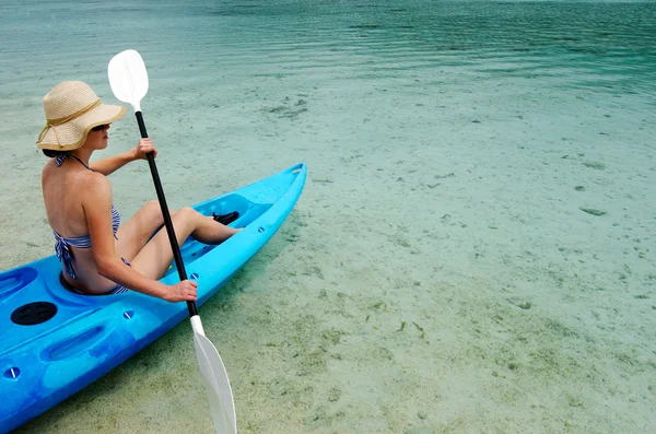 Young caucasian woman kayaking over turquoise water — Stock Photo, Image