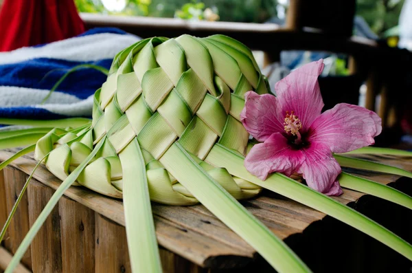 Chapeau de soleil genoux de feuilles de palmier — Photo