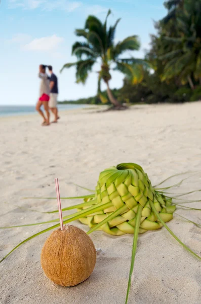Coconut and sun hat on the sandy sea shore — Stock Photo, Image
