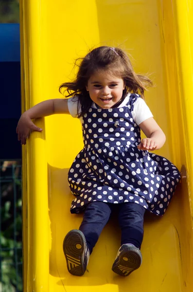 Little girl slides in playground — Stock Photo, Image