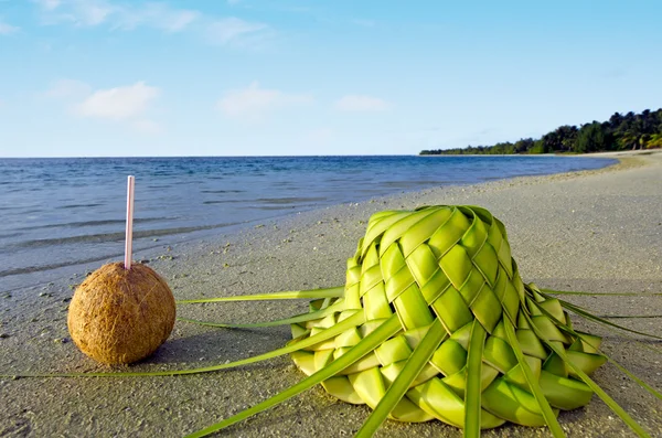 Un sombrero de coco y sol en la orilla del mar arenoso — Foto de Stock