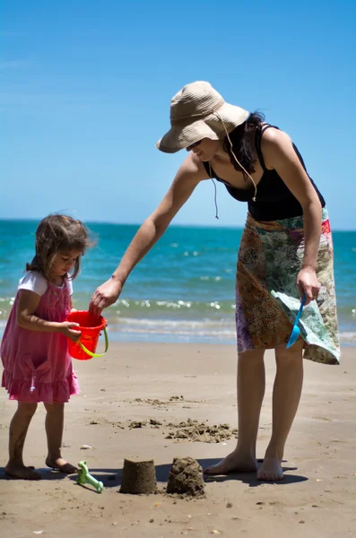 Mutter und Kind spielen am Strand — Stockfoto