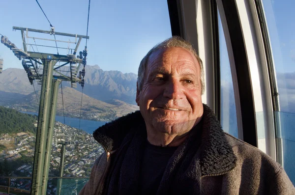 Mature man travel by aerial tramway — Stock Photo, Image