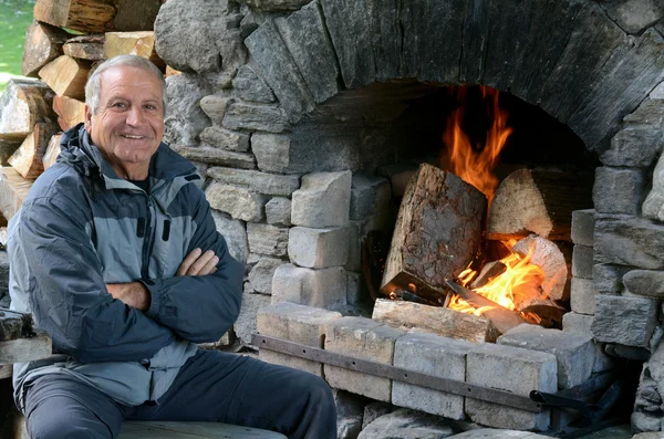 Mature man warm up with fireplace — Stock Photo, Image